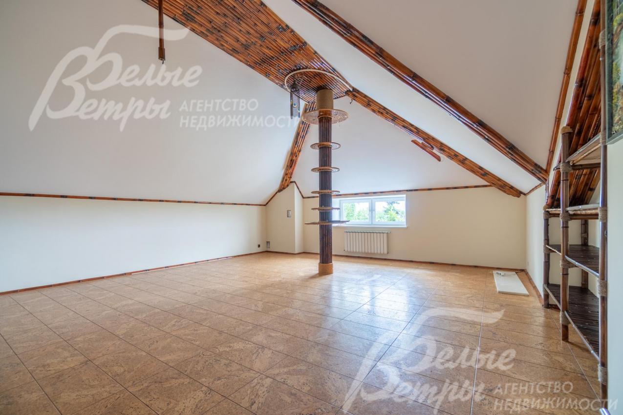 Холл на мансардном этаже украшен контрастными балками, установлены полки в цвет балок