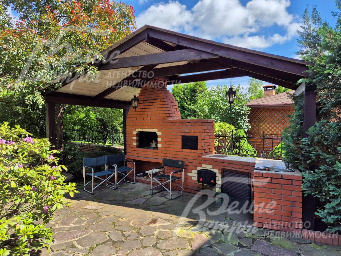 Зона барбекю на участке с печью-мангалом и водопроводом.