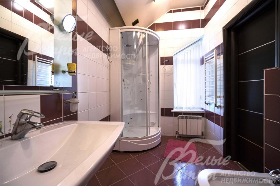 Санузел на втором этаже отделан контрастной плиткой в белых и коричневых цветах