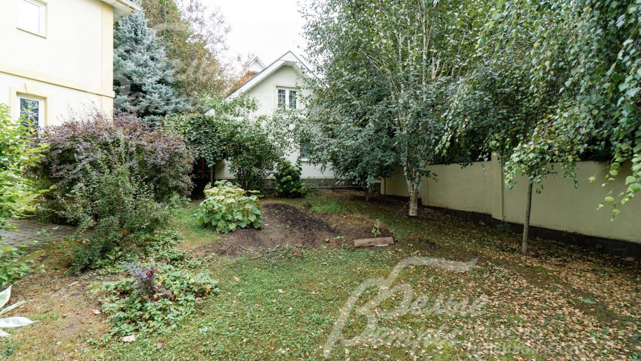 Участок огорожен высоким забором из кирпича