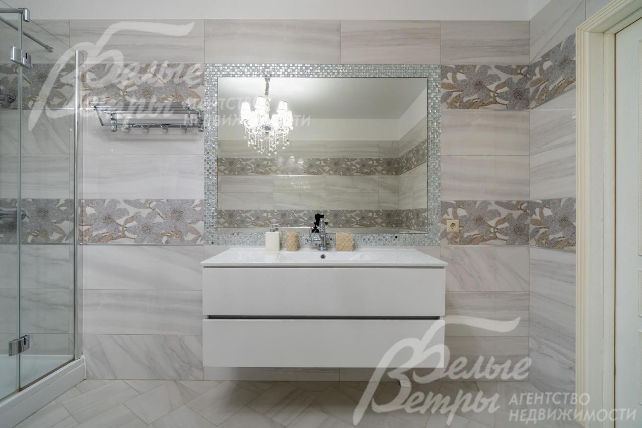 Санузел мастер-спальни отделан плиткой в благородных серых оттенках