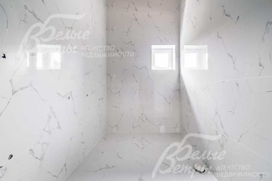 Санузел на втором этаже с отделкой белой плиткой под мрамор