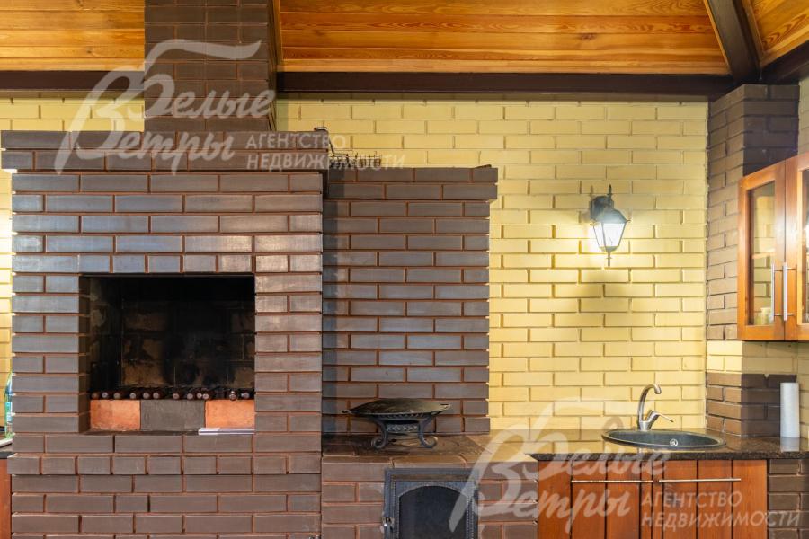 Печь из тёмного кирпича - с варочной зоной с чугунной решёткой, гармонично вписана в интерьер беседки