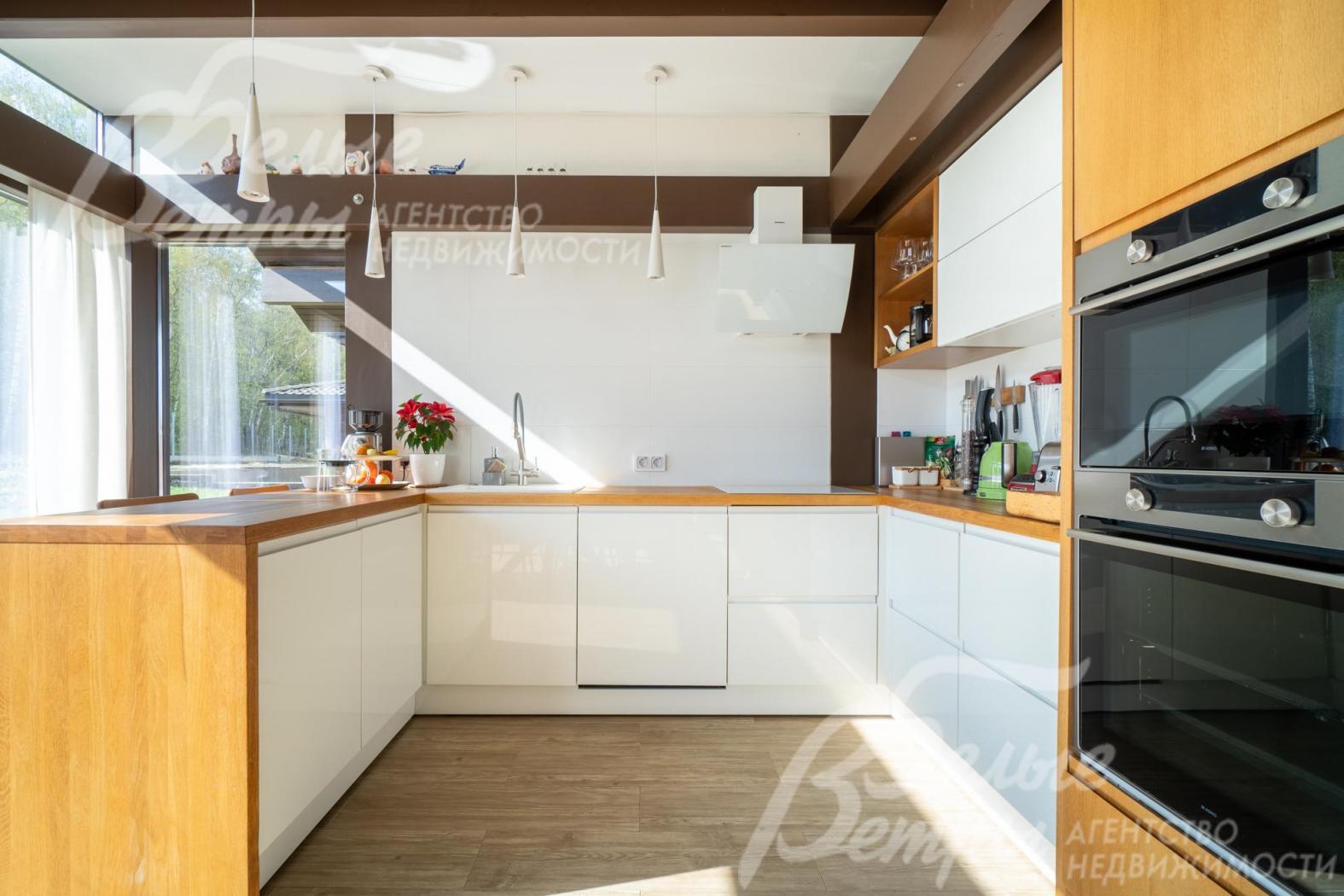 На кухне – гарнитур с дубовой столешницей и фасадом из дубового шпона со встроенной бытовой техникой 