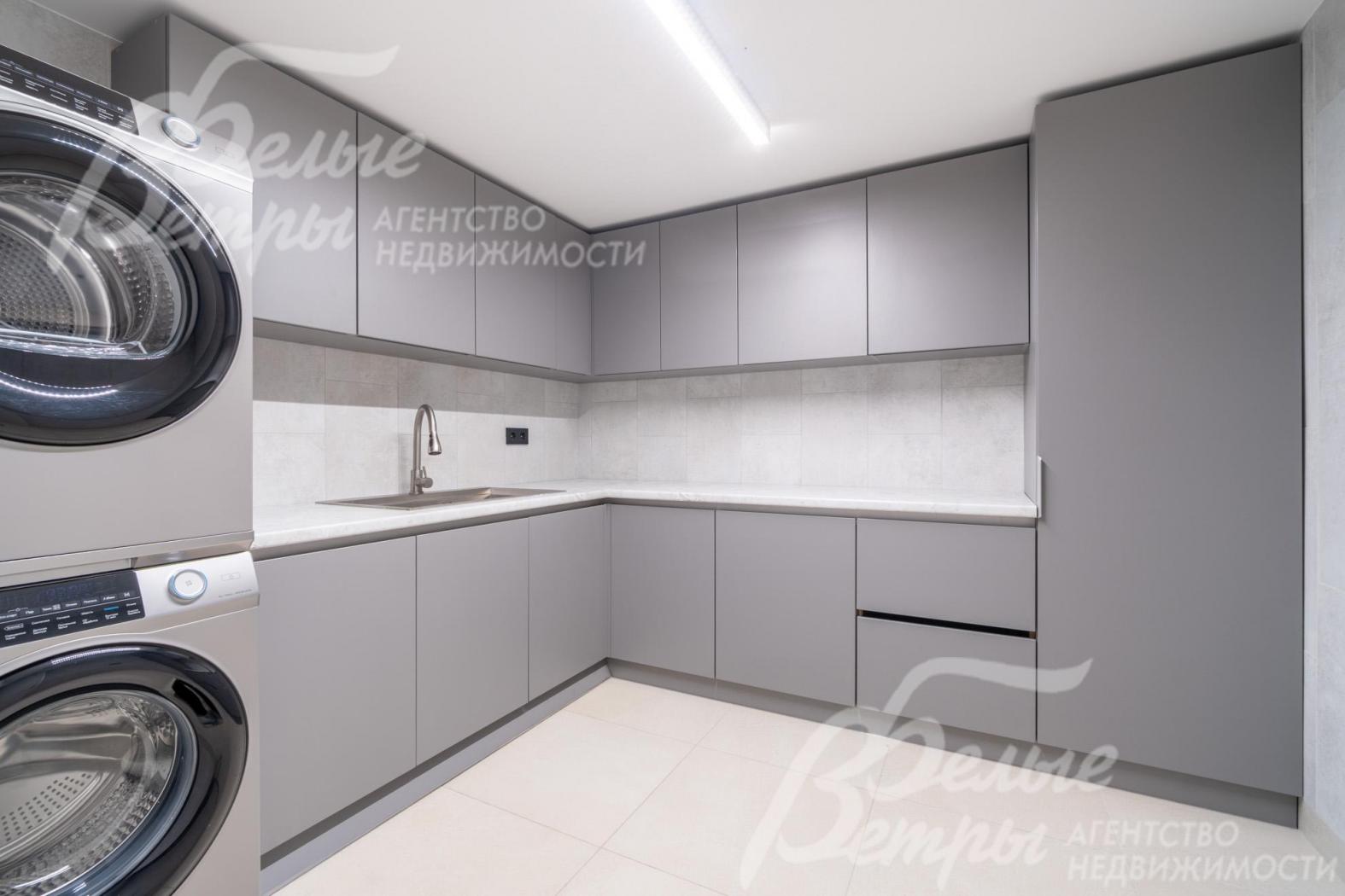 Оборудованная постирочная: вместительные закрытые шкафы, стиральная и сушильная машины Haier