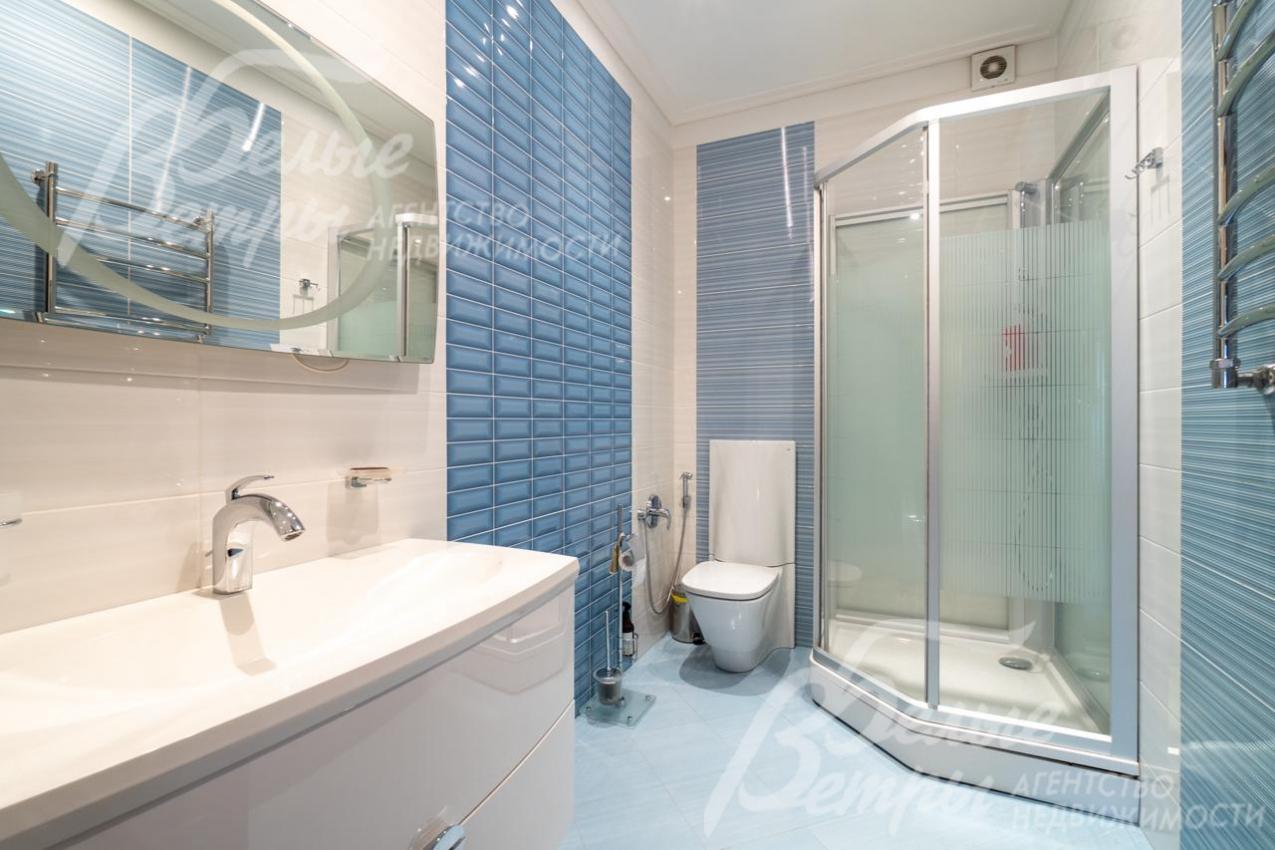 Один из санузлов на втором этаже в светло-голубых тонах с душевой кабиной