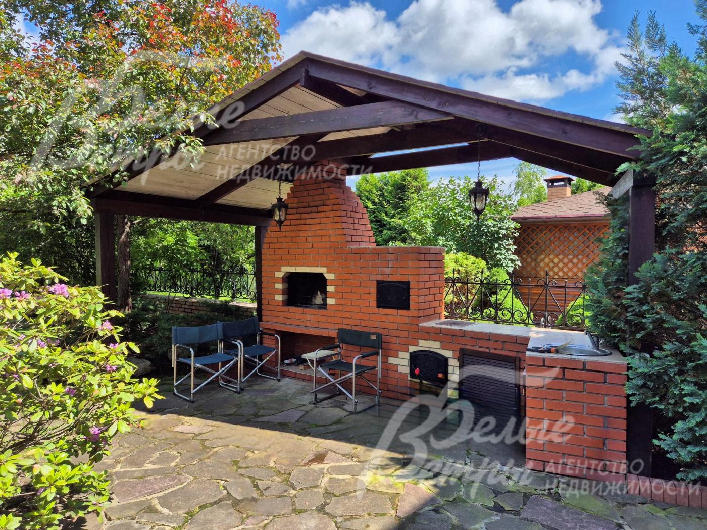 Зона барбекю на участке с печью-мангалом и водопроводом.