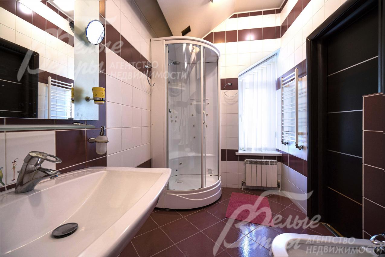 Санузел на втором этаже отделан контрастной плиткой в белых и коричневых цветах