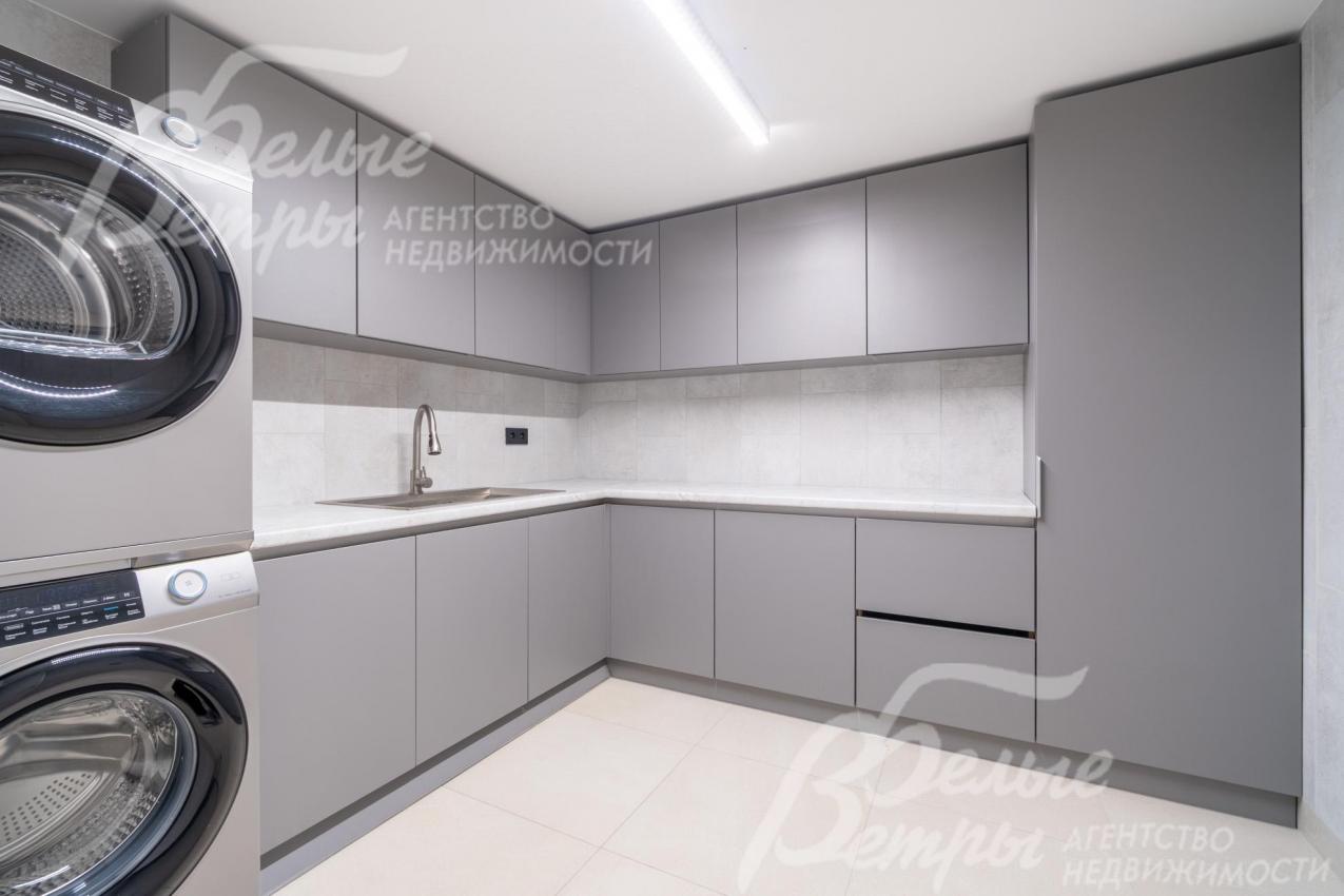 Оборудованная постирочная: вместительные закрытые шкафы, стиральная и сушильная машины Haier