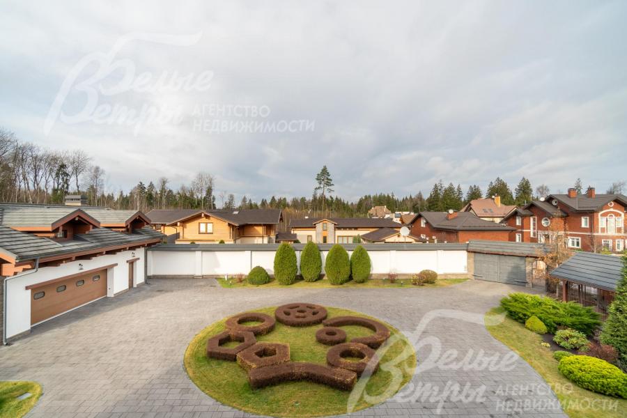 С лоджии открывается вид на центральную клумбу участка, соседние дома и лес