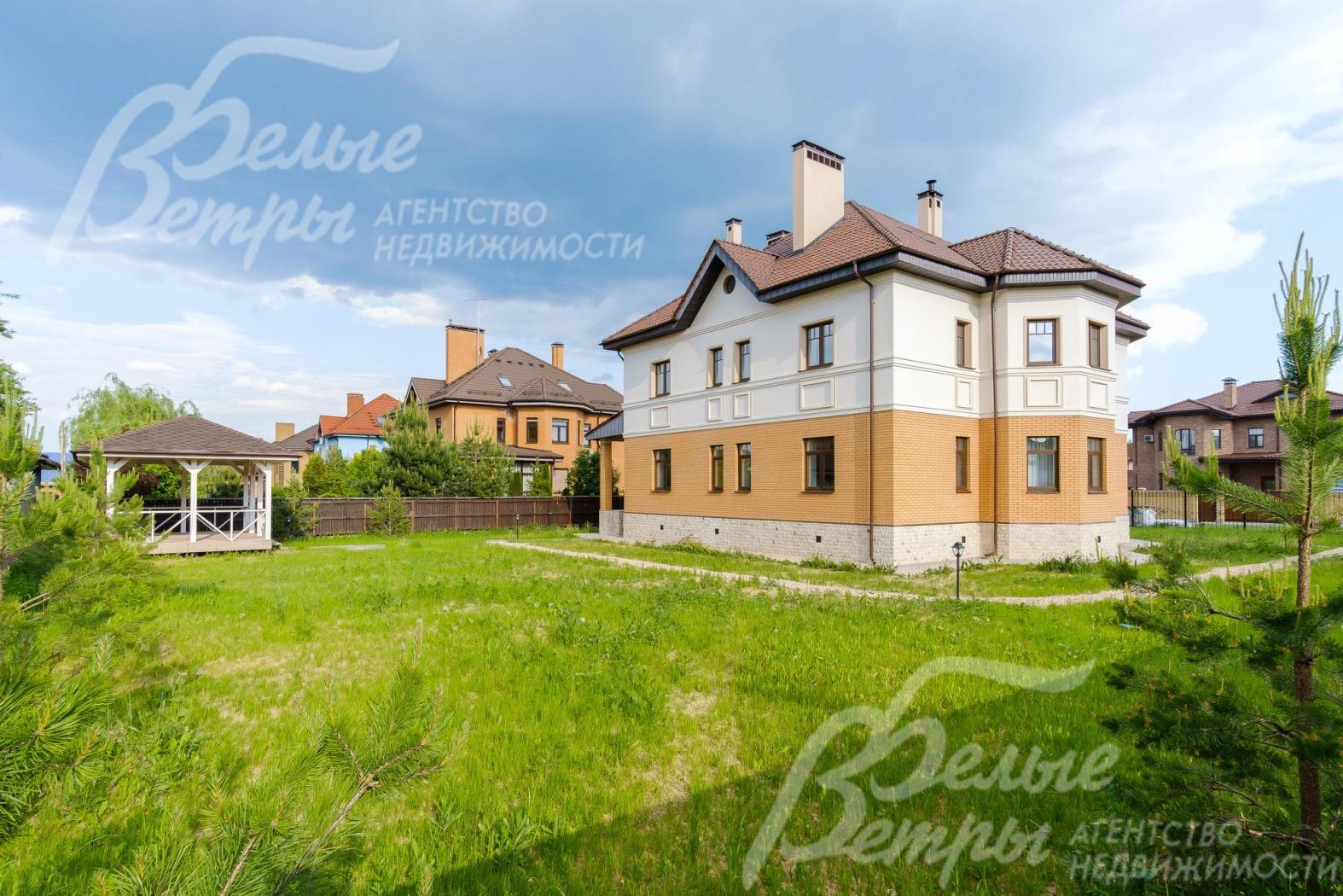 На участке газон, высажены хвойные деревья