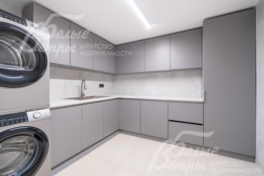 Оборудованная постирочная: вместительные закрытые шкафы, стиральная и сушильная машины Haier