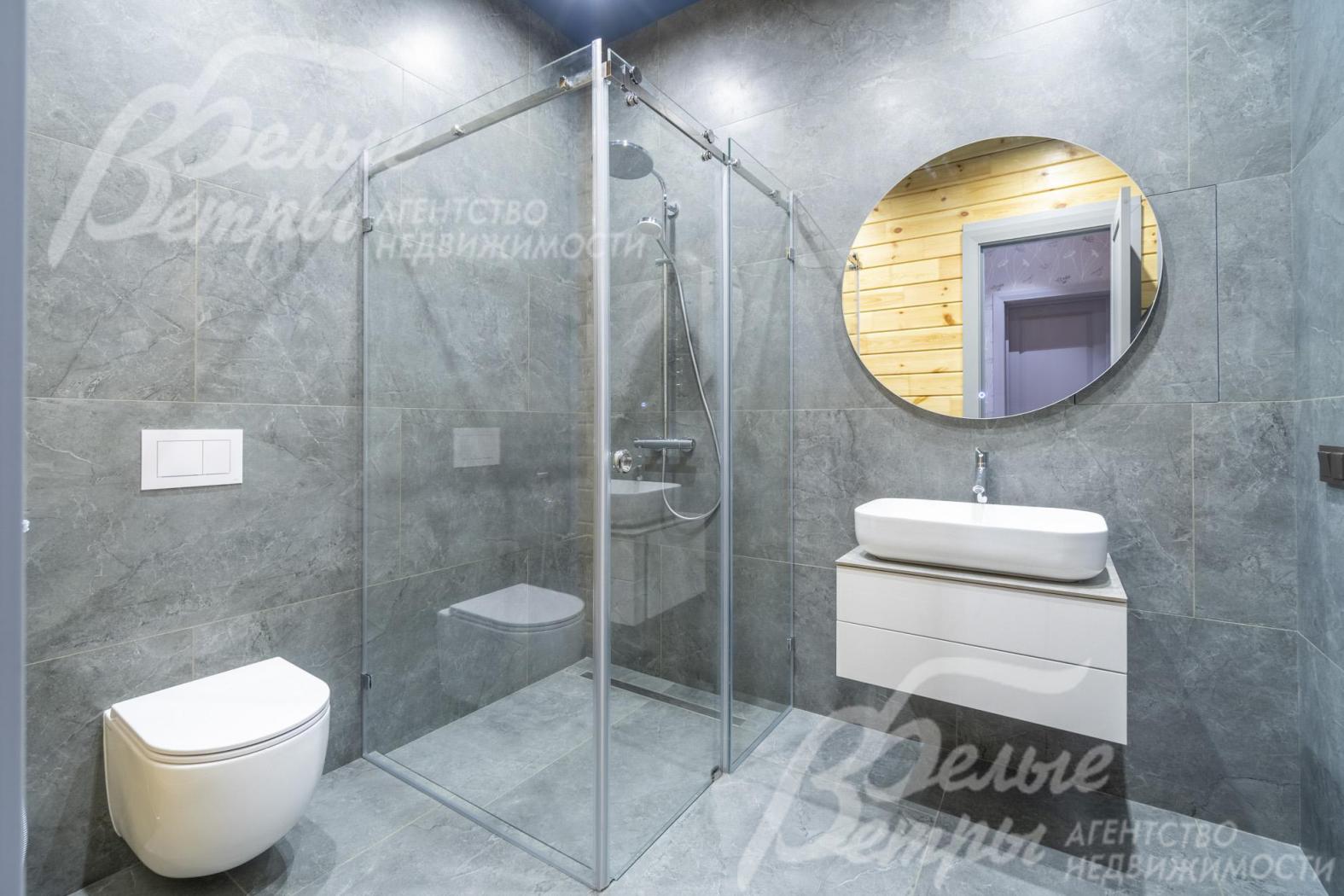 Санузел мастер-спальни с отделкой крупноформатным керамогранитом под серый мрамор.