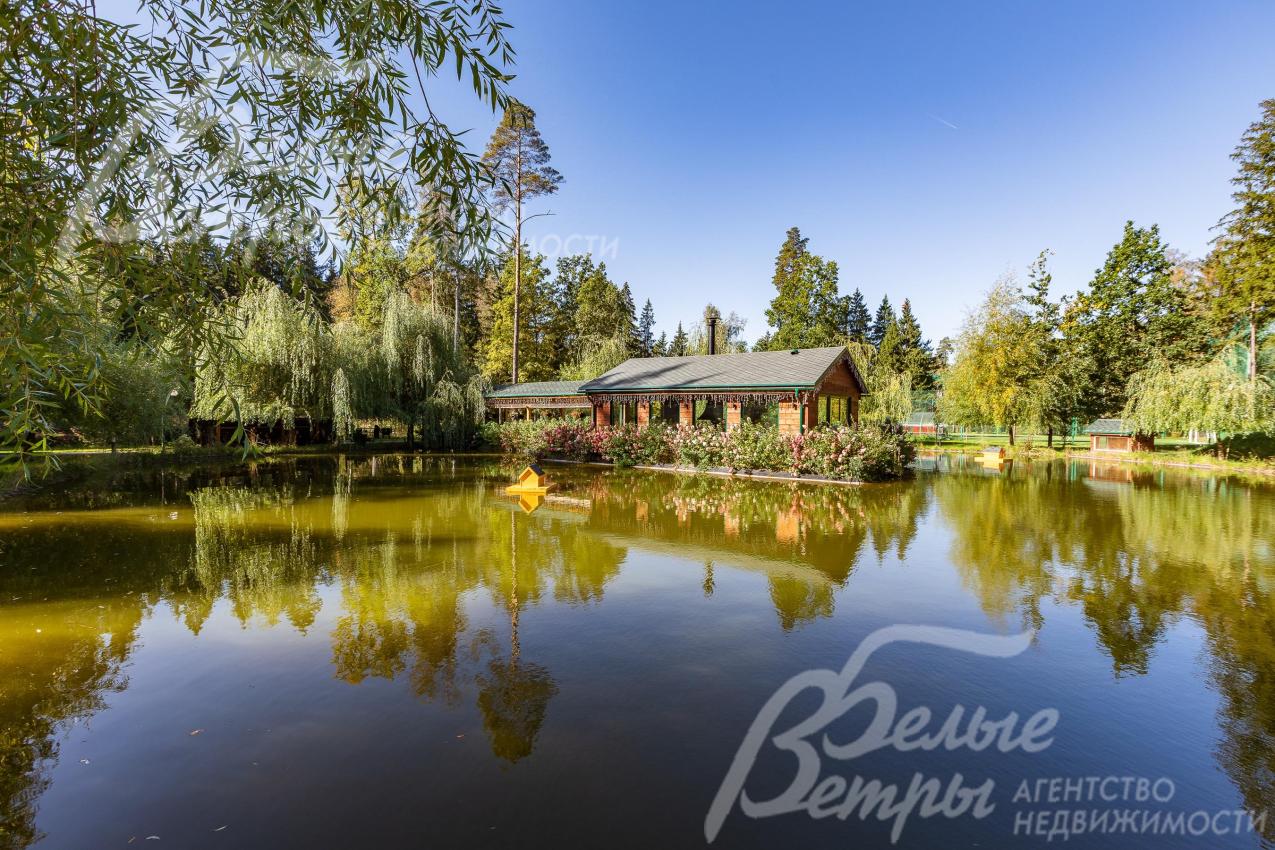 Эффектная отапливаемая беседка с барбекю стоит на острове в центре собственного пруда