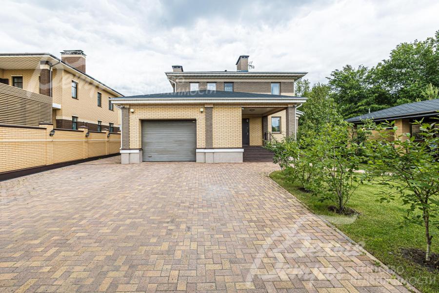 Парковка перед гаражом вымощена брусчаткой.