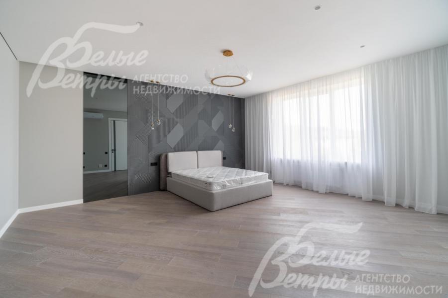 Просторная спальня на втором этаже с большим окном и кроватью