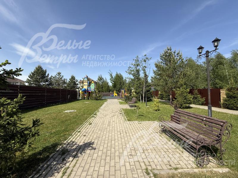 Прогулочная зона уложена плиткой, установлены скамейки и уличные фонари