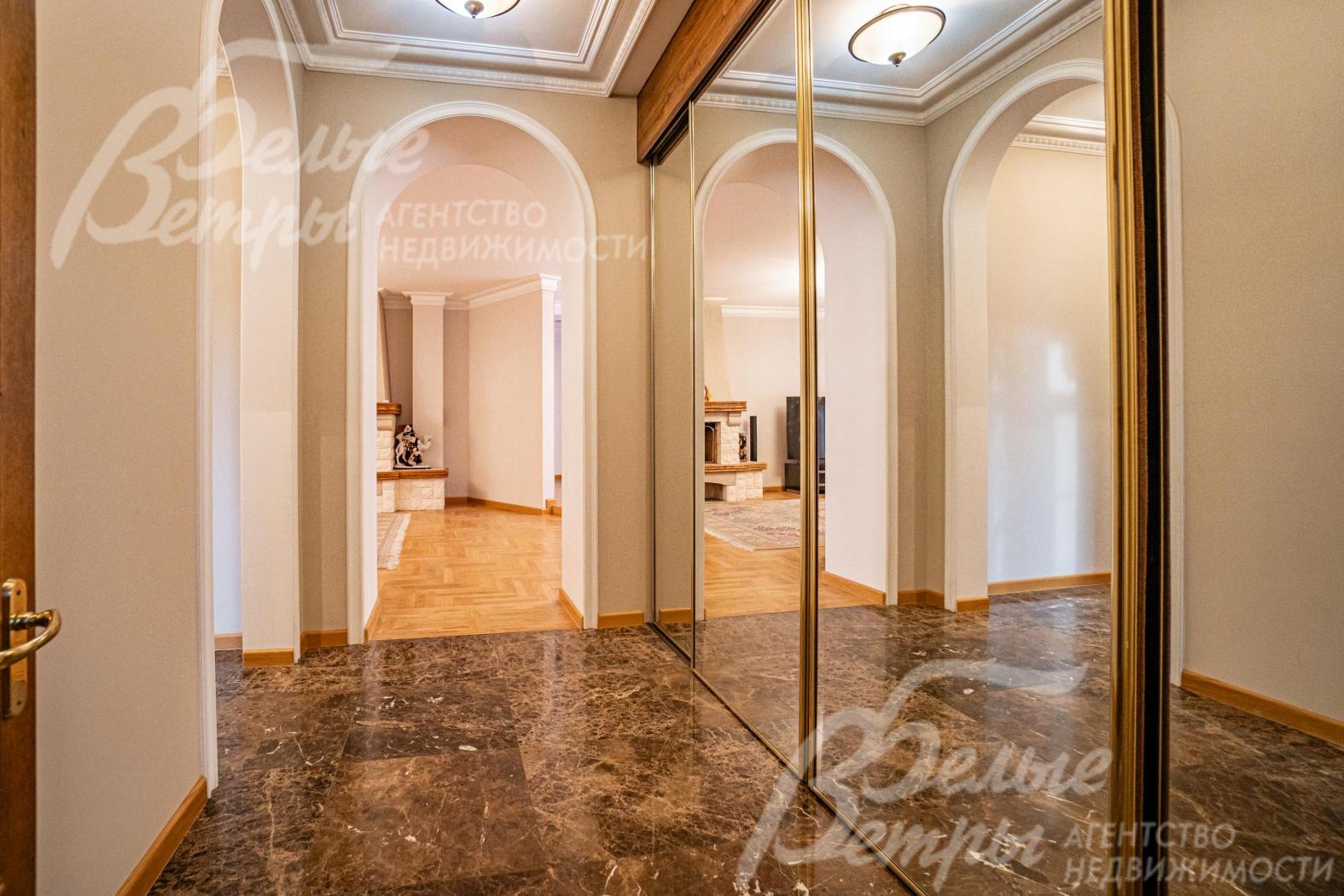 Вместительный большой шкаф в прихожей. На полу мрамор.