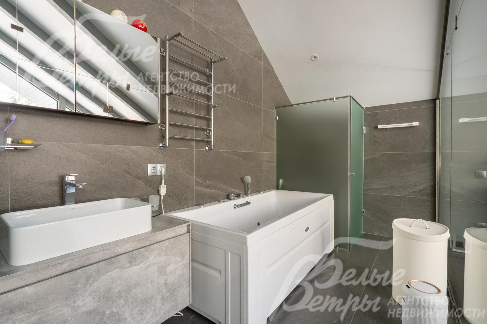 Поверхность тумбы под раковиной и стены облицованы керамогранитом с текстурой под камень, что добавляет интерьеру глубины и респектабельности