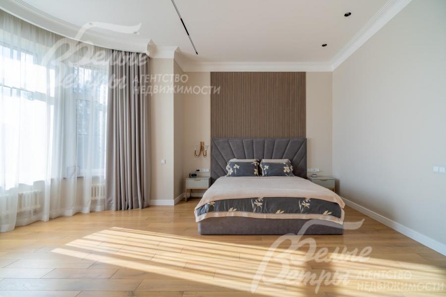 Стена у изголовья декорирована 3D-панелью, на полу - дубовая инженерная доска