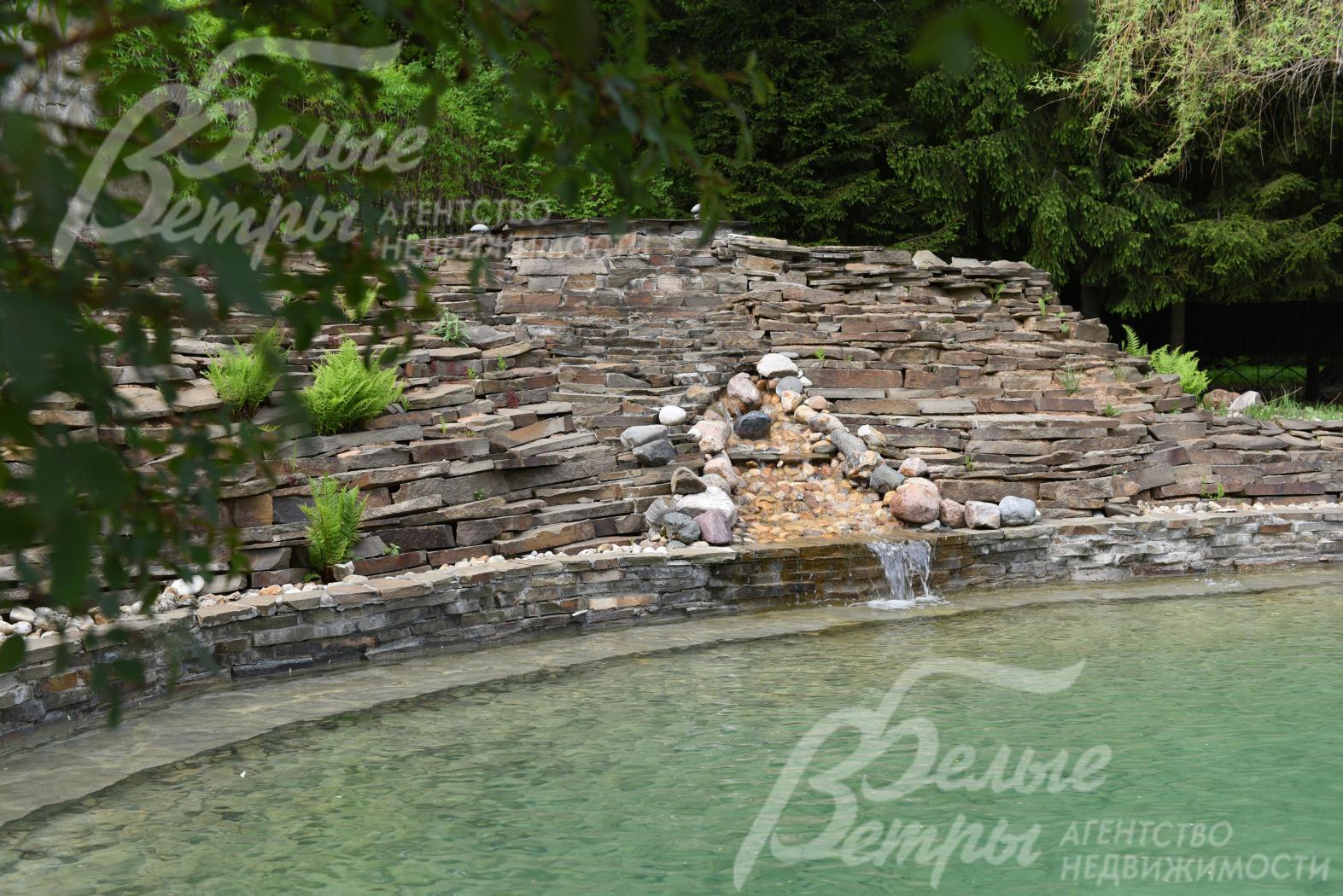 Альпийская горка с водопадом и открытый скиммерный бассейн с системой водоочистки и постоянной циркуляцией воды, оформленный как природный водоем