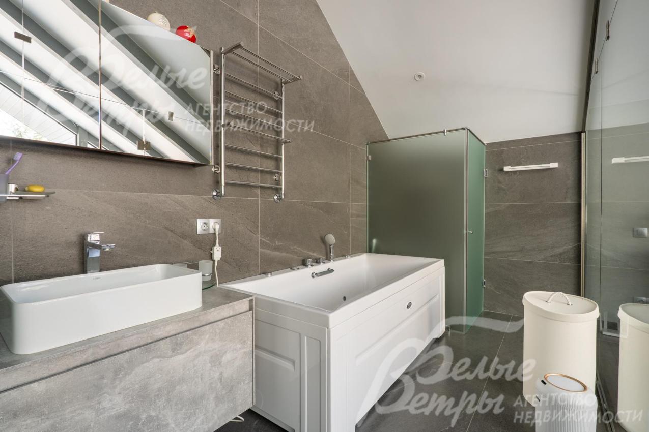 Поверхность тумбы под раковиной и стены облицованы керамогранитом с текстурой под камень, что добавляет интерьеру глубины и респектабельности