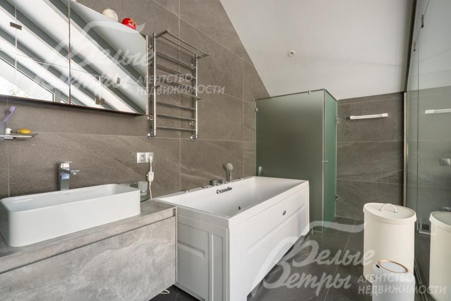 Поверхность тумбы под раковиной и стены облицованы керамогранитом с текстурой под камень, что добавляет интерьеру глубины и респектабельности