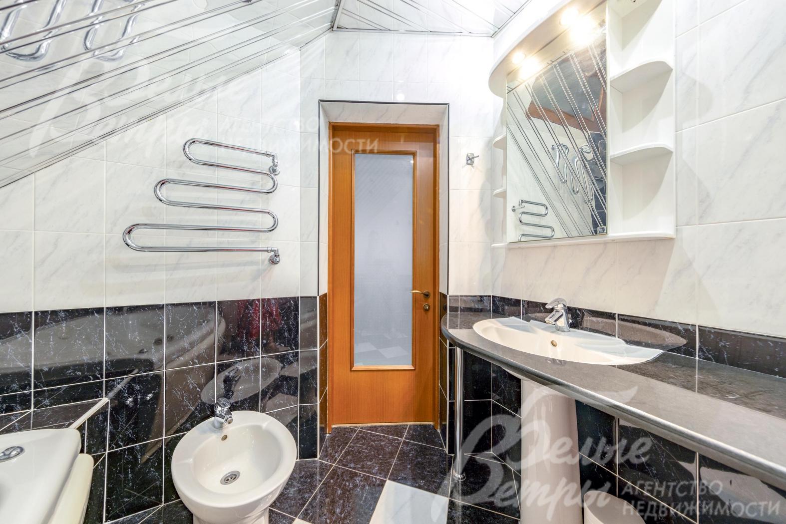 Санузел на втором этаже с контрастной отделкой чёрной и белой плиткой под мрамор