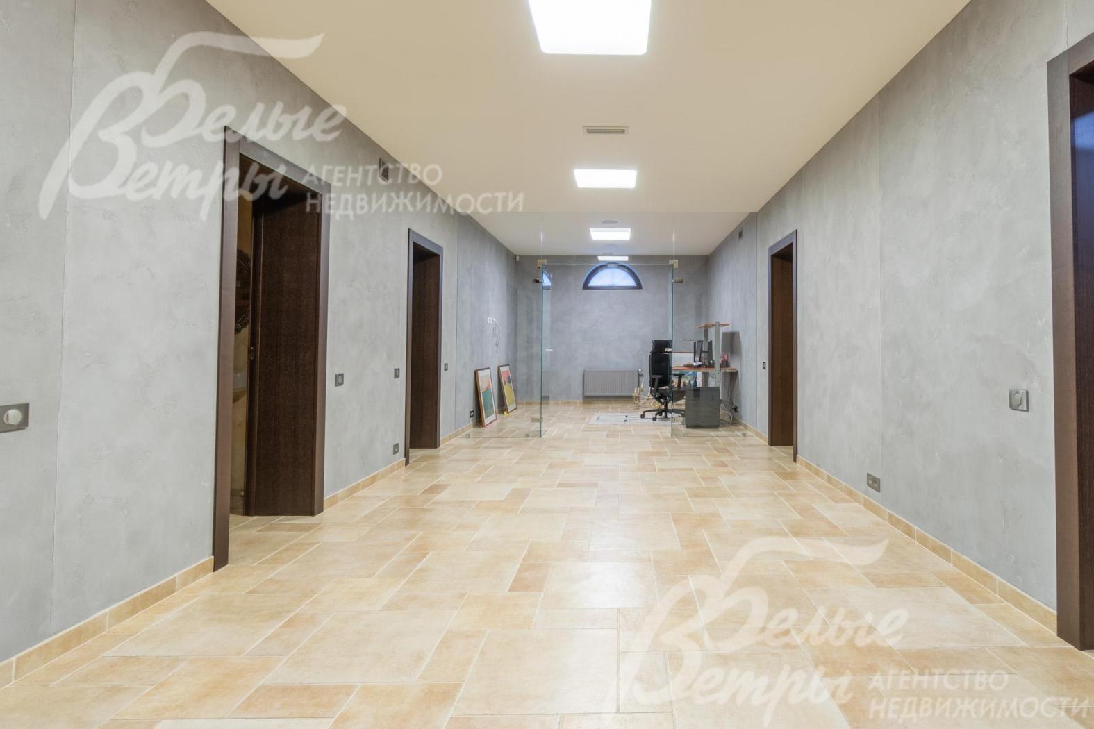 Холл цокольного этажа. В конце него - кабинет с оборудованным рабочим местом и со стеклянной дверью