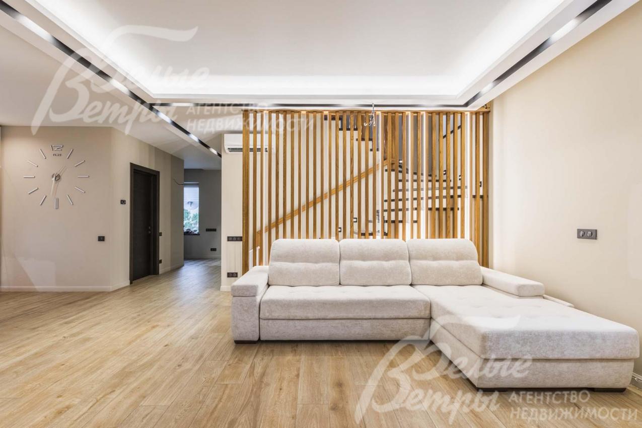 В гостиной двухуровневый потолок с декоративными черными нишами с подсветкой