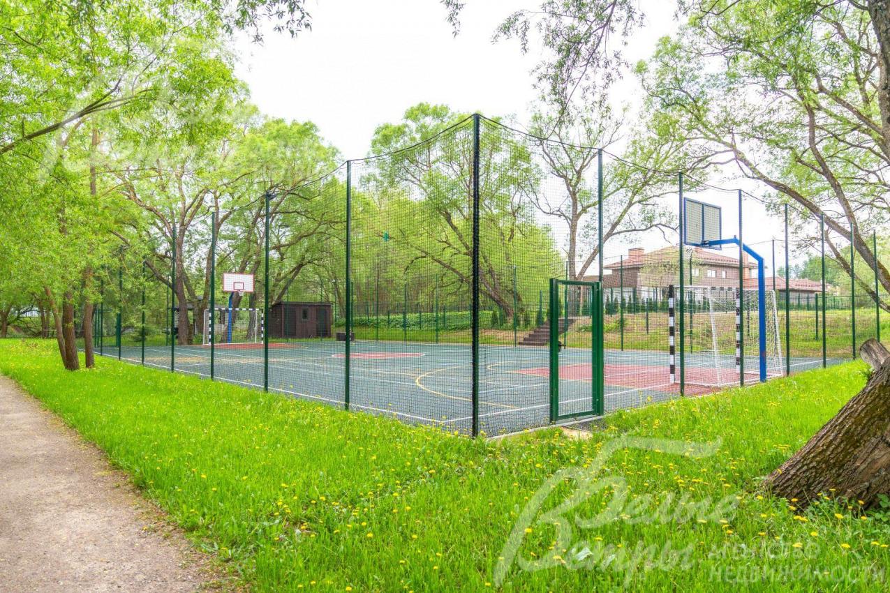 Огороженная спортивная площадка с твёрдым покрытием.