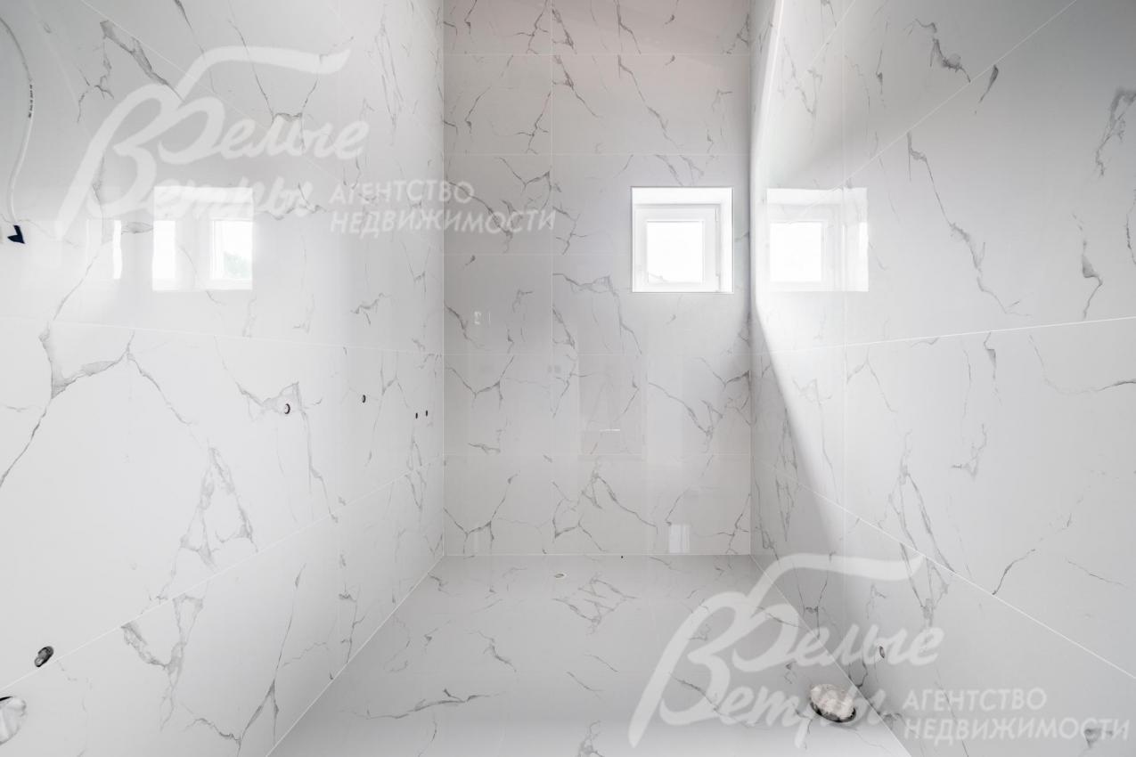 Санузел на втором этаже с отделкой белой плиткой под мрамор