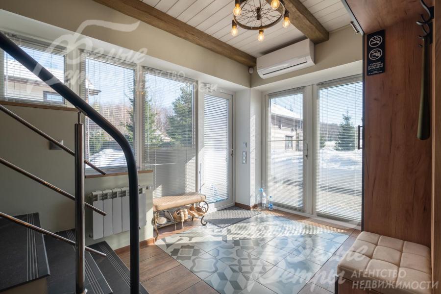 Вход в дом - через просторную прихожую с панорамными стеклянными дверями (за лестницей есть чемоданная комната)