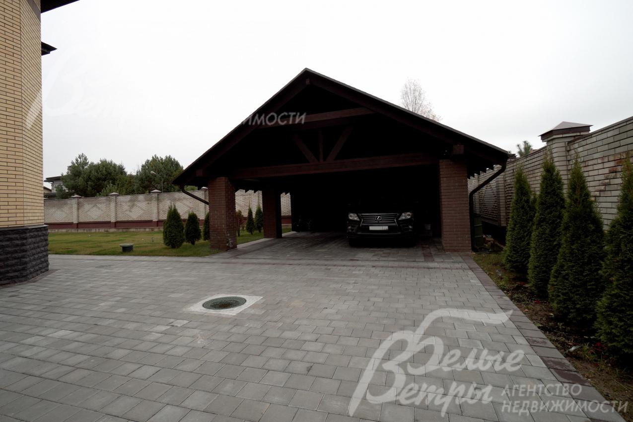 Рядом с домом - навес для двух автомобилей с хозяйственным блоком, а также просторная парковка 