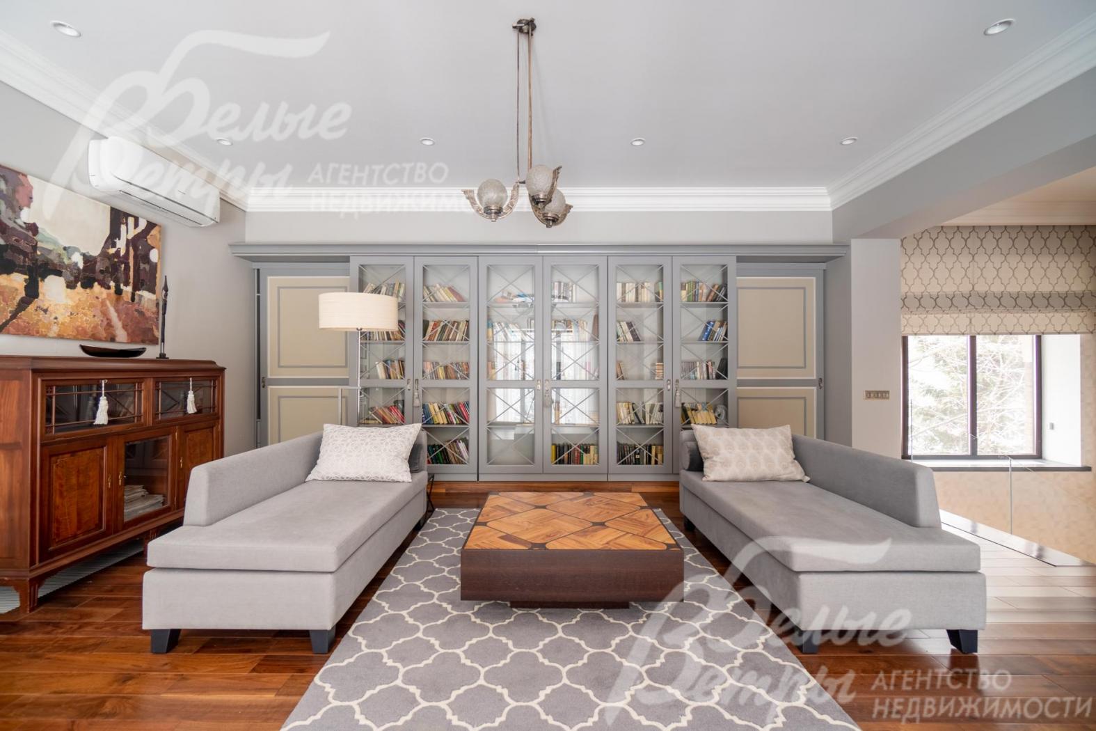 Большой книжный шкаф холла-галереи раздвигается по направляющим, открывая спрятанный за ним одежный шкаф во всю длину стены.