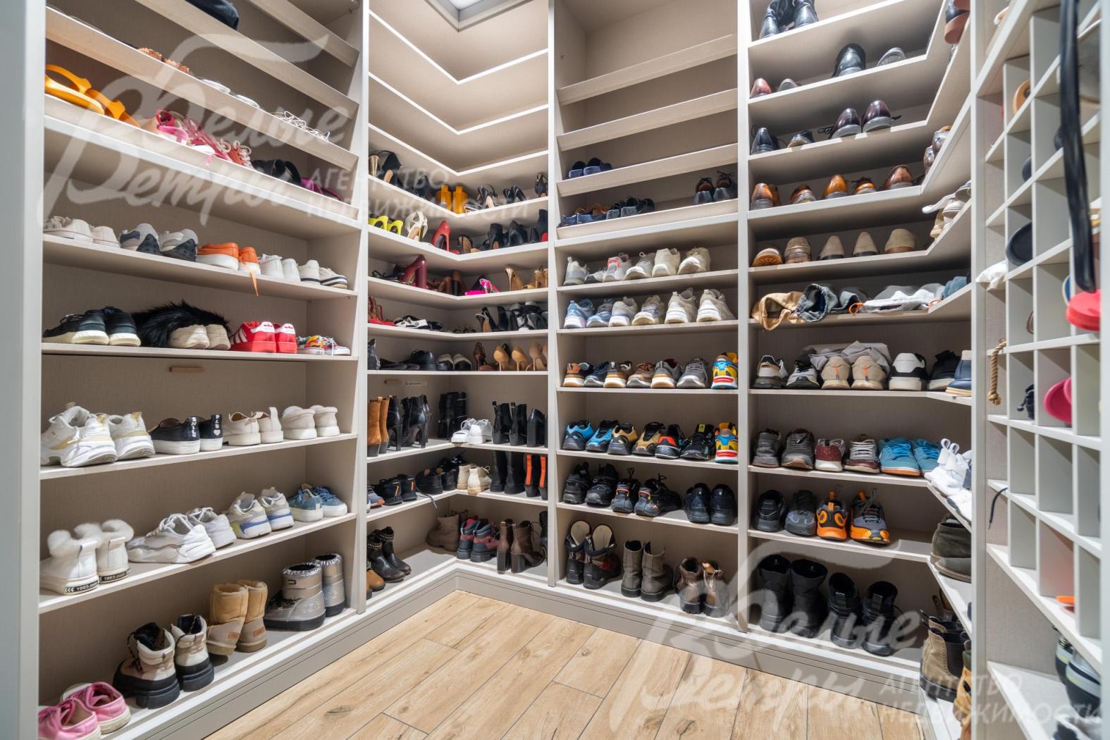 Одна из гардеробных выполнена в формате обувницы: предусмотрены полки для обуви, занимающие всю высоту помещения — от пола до потолка