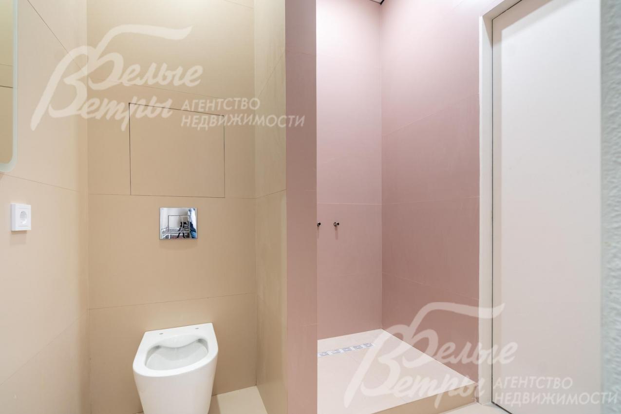 Санузел на первом этаже с душевой, плитка в пастельной гамме создаёт тёплый, уютный фон