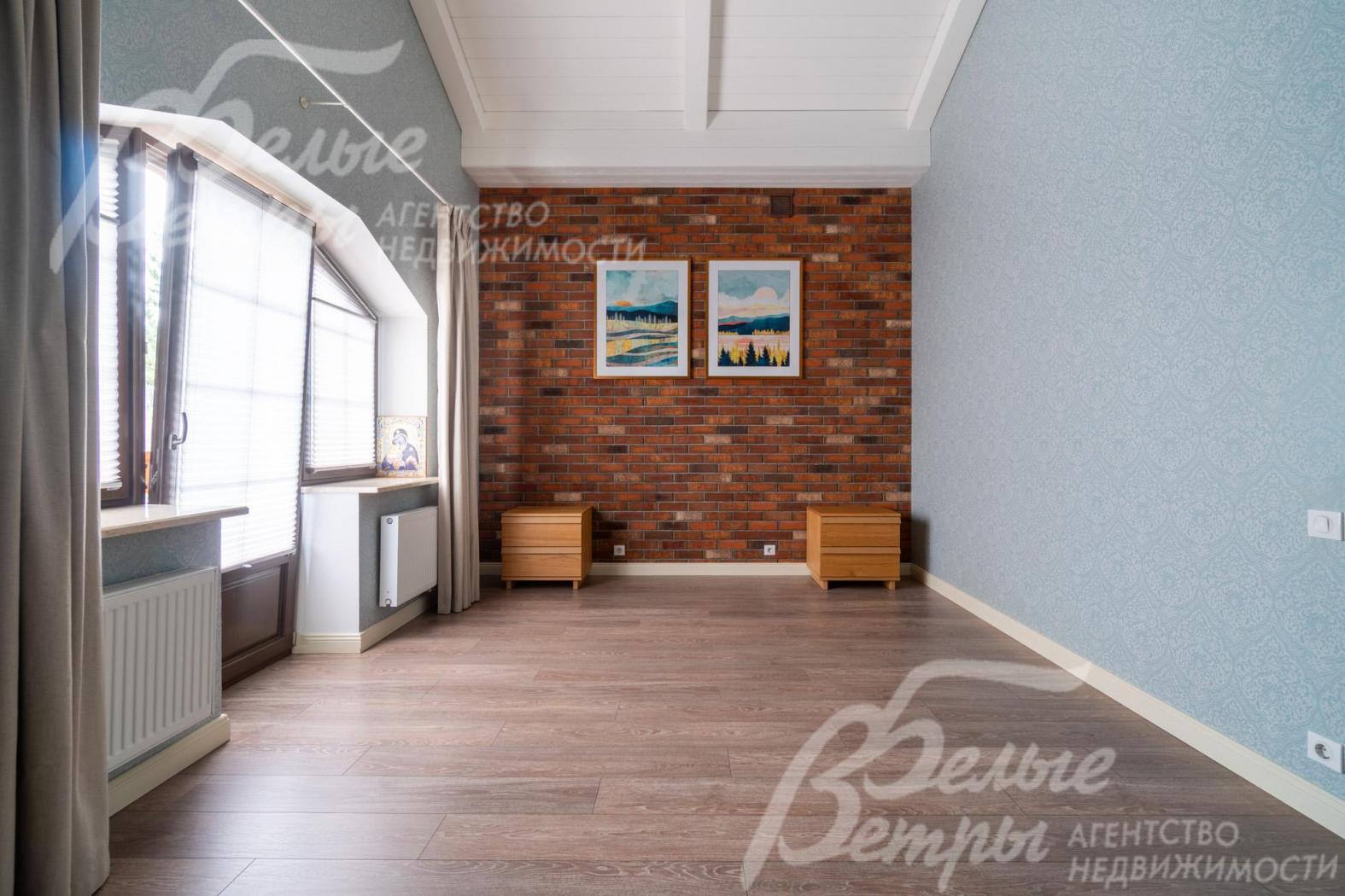 Спальня на втором этаже с декоративной кирпичной стеной и выходом на террасу