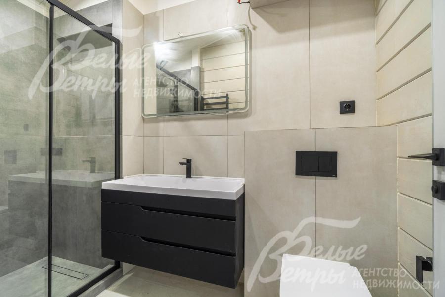 В санузлах на стенах - плитка светло-серого цвета, на полу - керамогранит с водяным подогревом