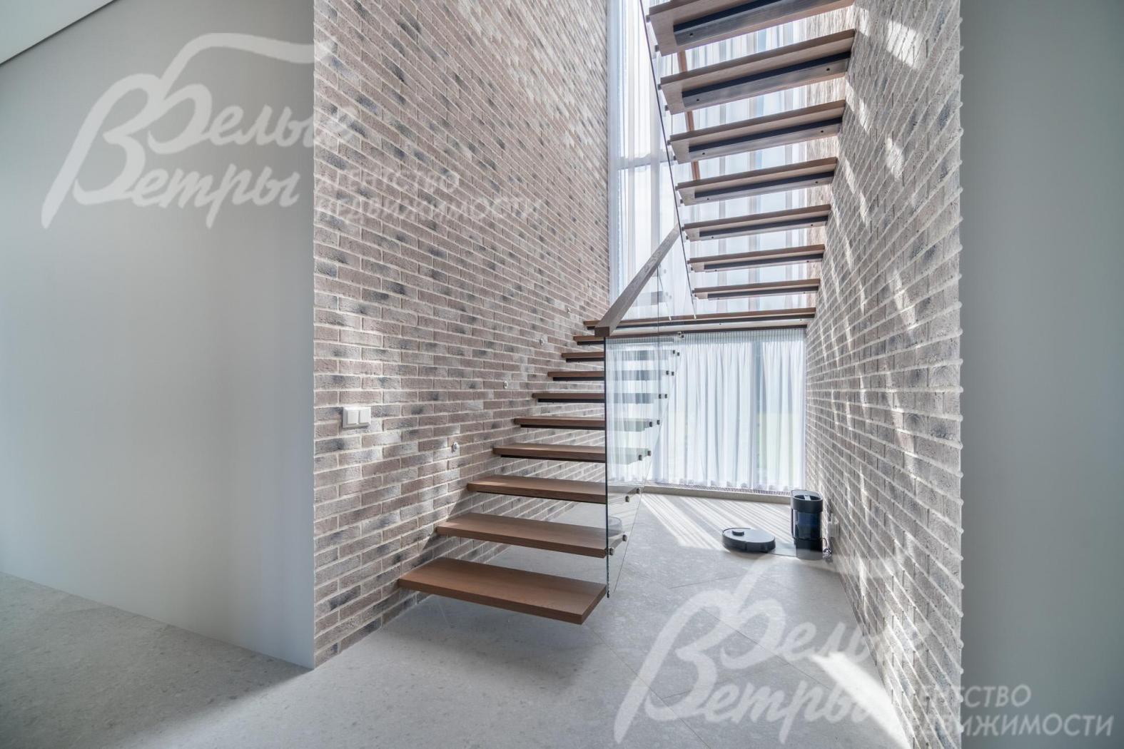 На второй этаж ведёт парящая лестница на тонком стальном каркасе со ступенями из массива дуба