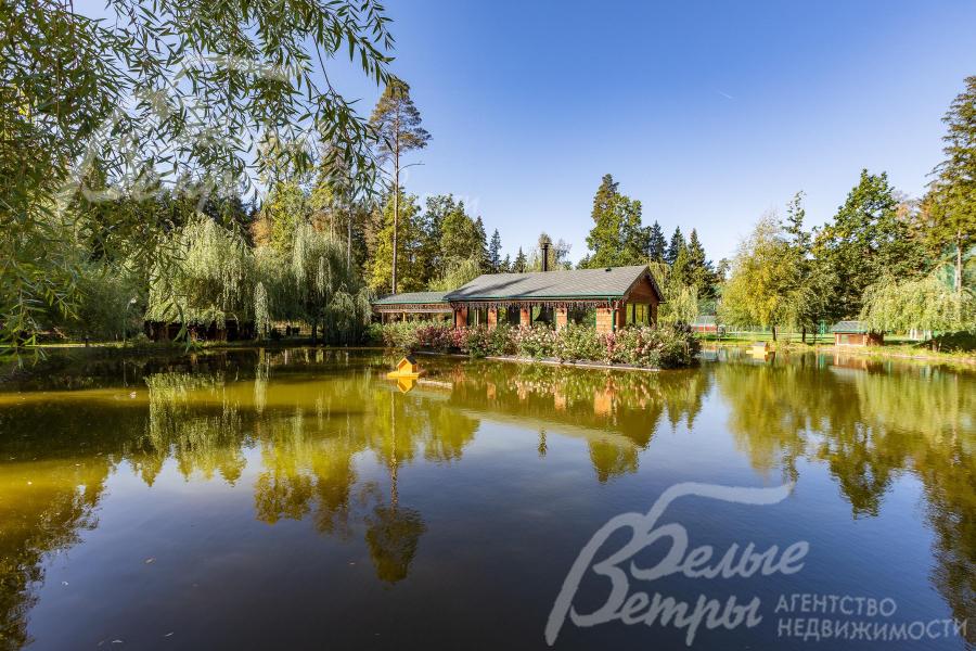 Эффектная отапливаемая беседка с барбекю стоит на острове в центре собственного пруда