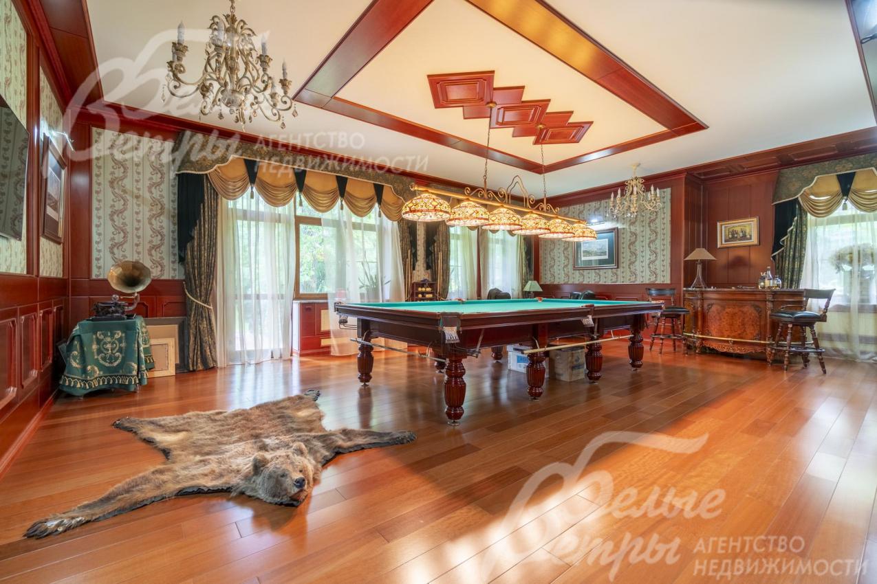 Просторная бильярдная на первом этаже с широкой площадью остекления