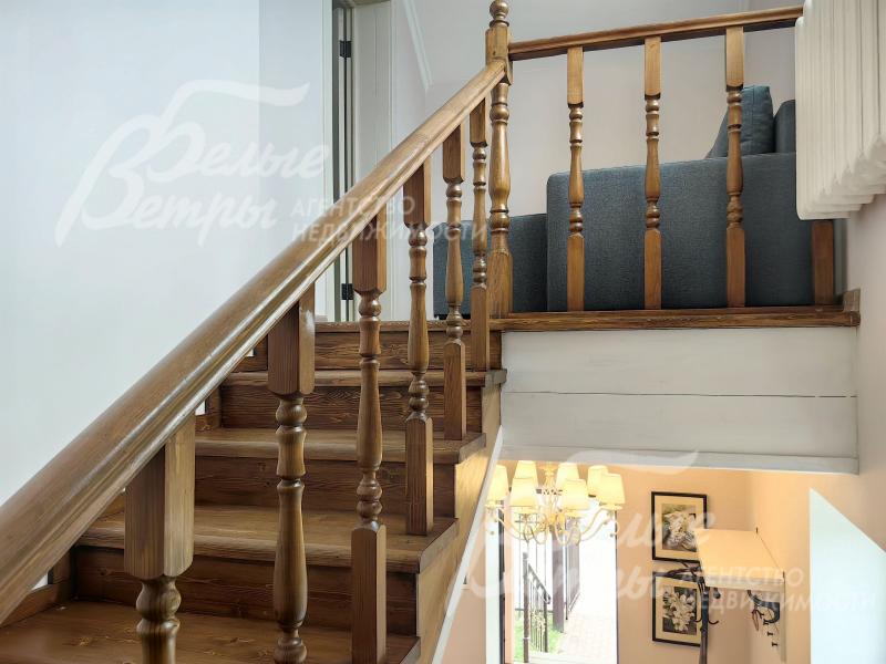 Лестница из массива сосны с деревянными перилами.