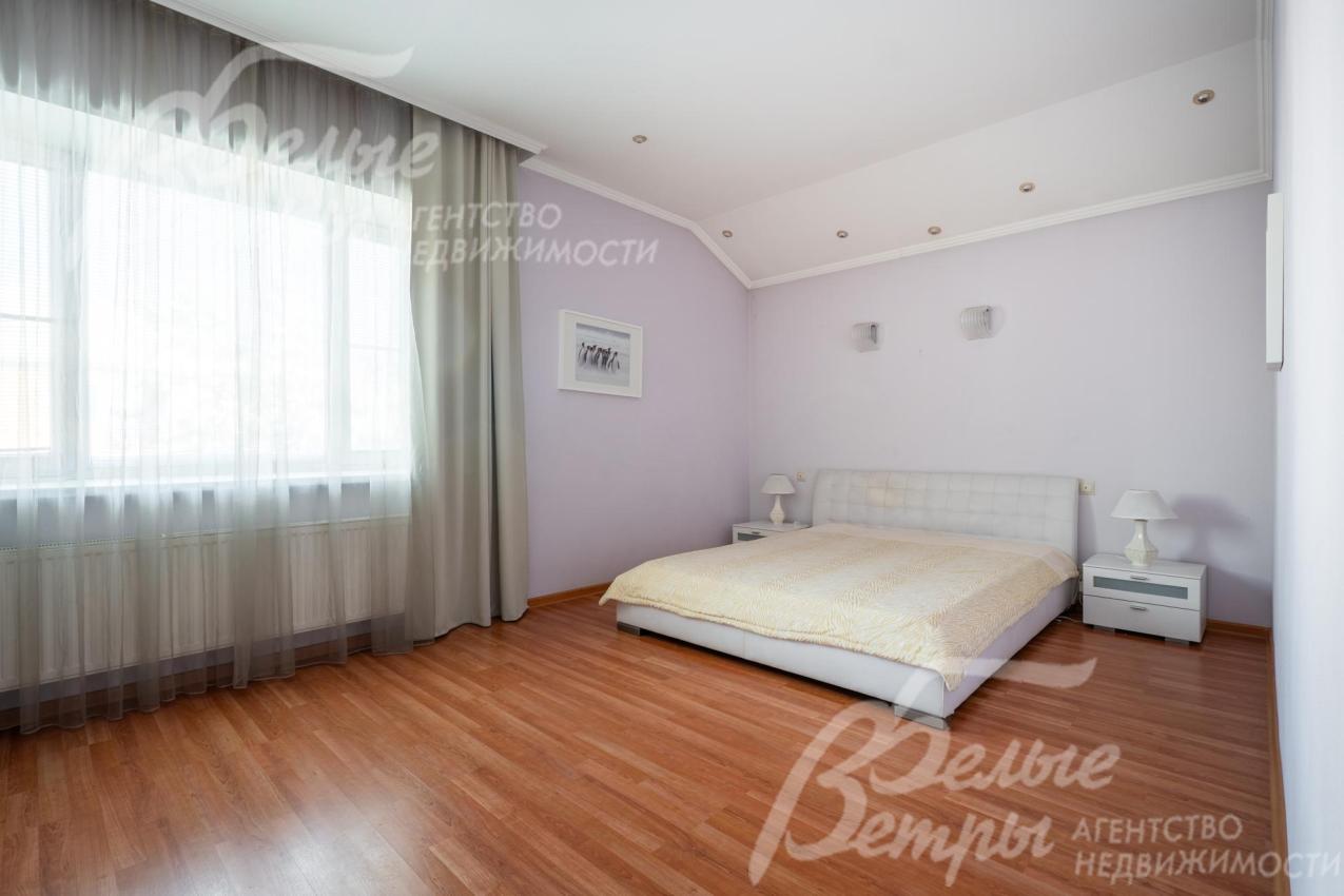 Одна из спален на втором этаже. Стены окрашены в нежный светло-лиловый оттенок, который придаёт комнате мягкость и визуально расширяет пространство