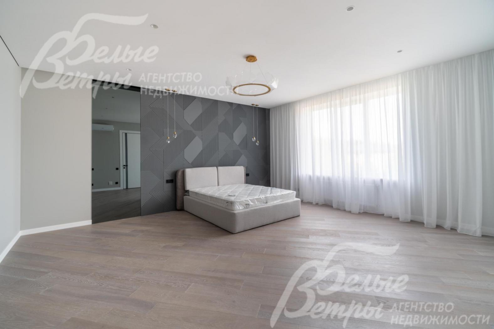 Просторная спальня на втором этаже с большим окном и кроватью