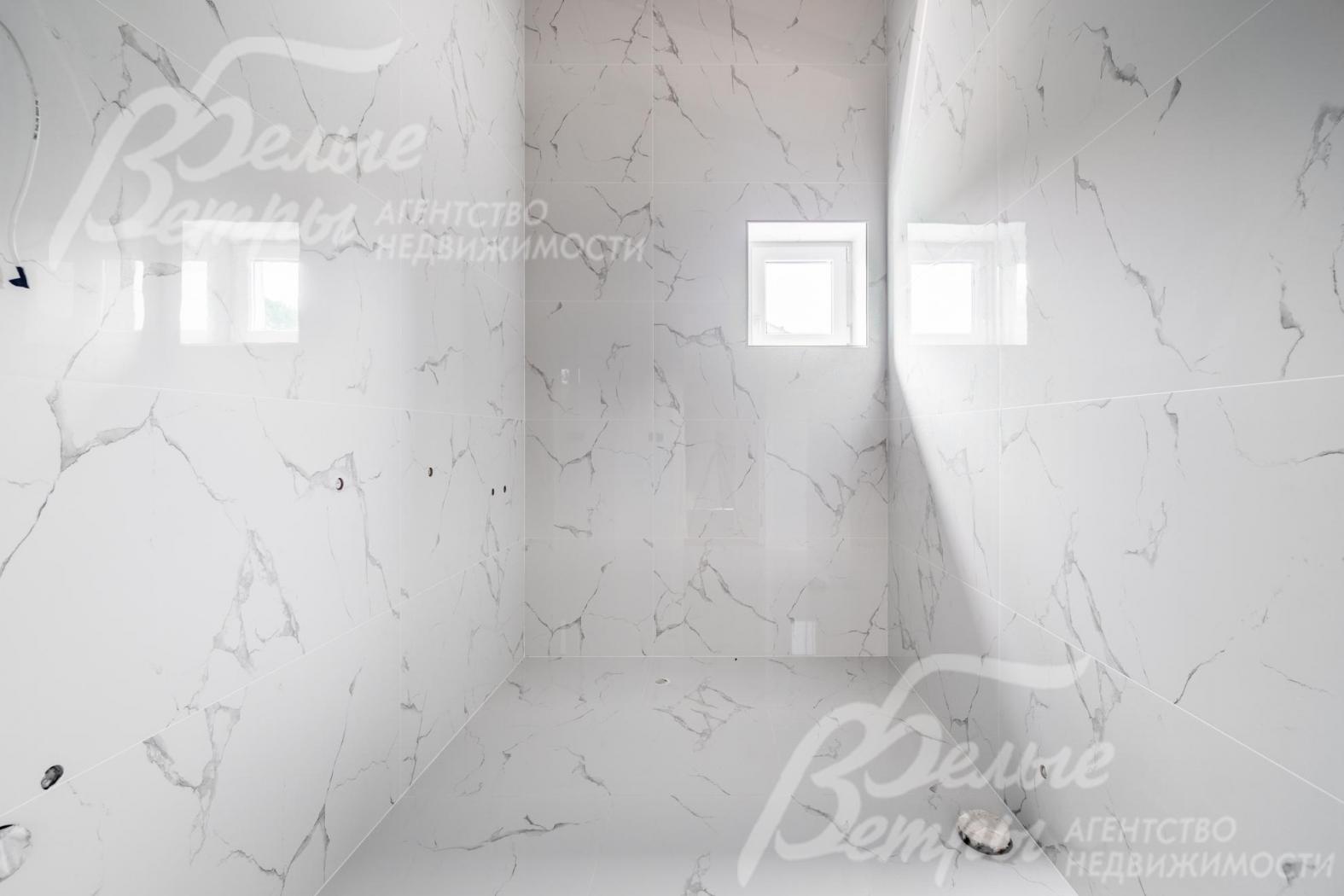 Санузел на втором этаже с отделкой белой плиткой под мрамор