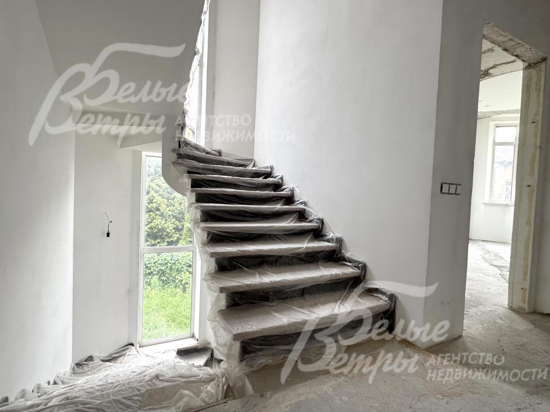 На второй этаж ведёт монолитная лестница: ступени обшиты износостойким белёным дубом