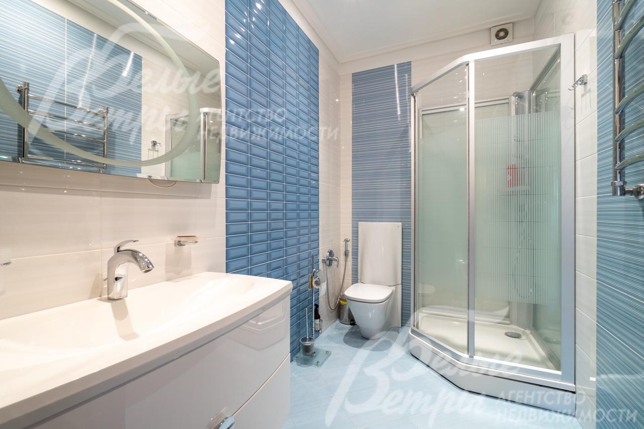 Один из санузлов на втором этаже в светло-голубых тонах с душевой кабиной