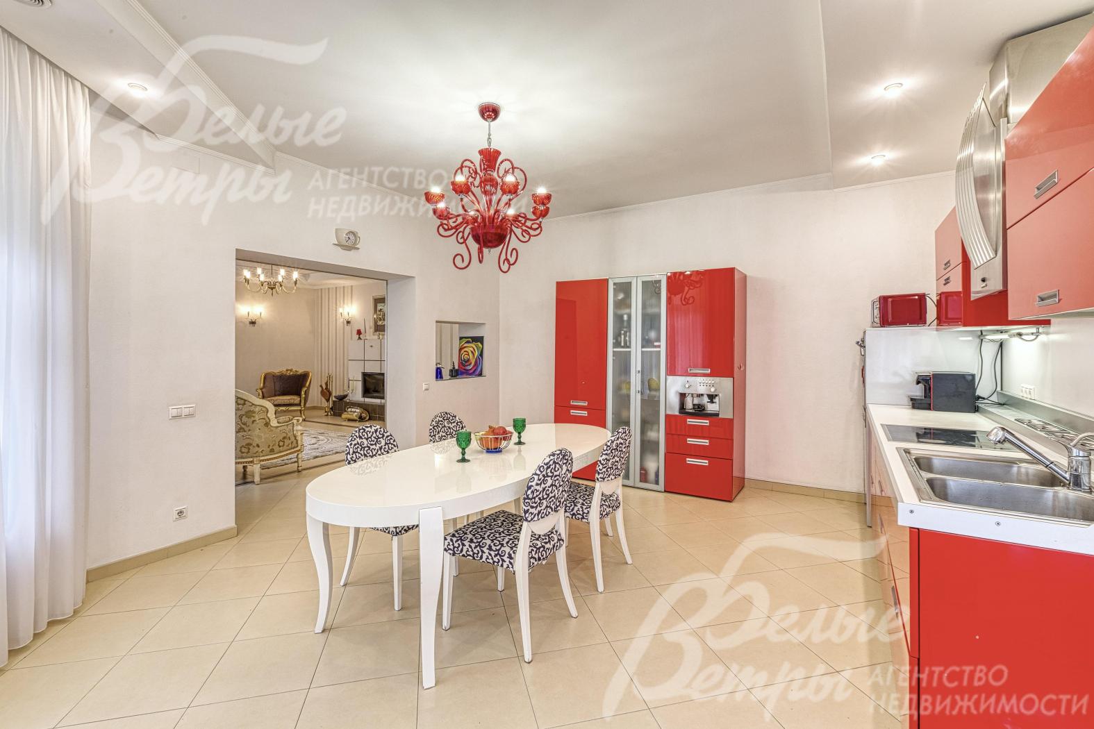 Кухню украшает дорогостоящая люстра красного оттенка в тон фасадов гарнитура