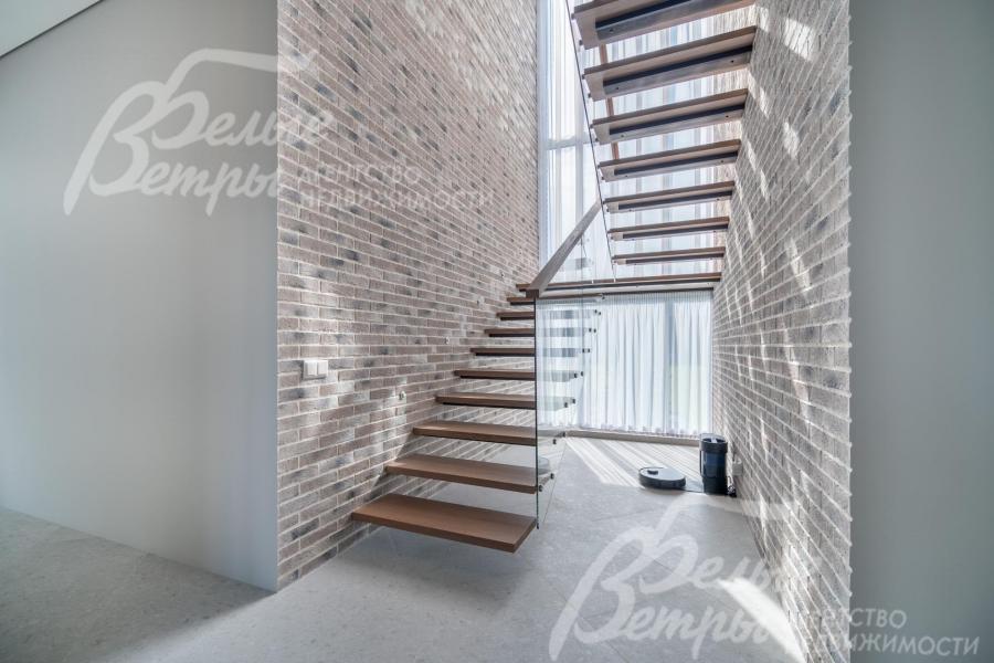 На второй этаж ведёт парящая лестница на тонком стальном каркасе со ступенями из массива дуба